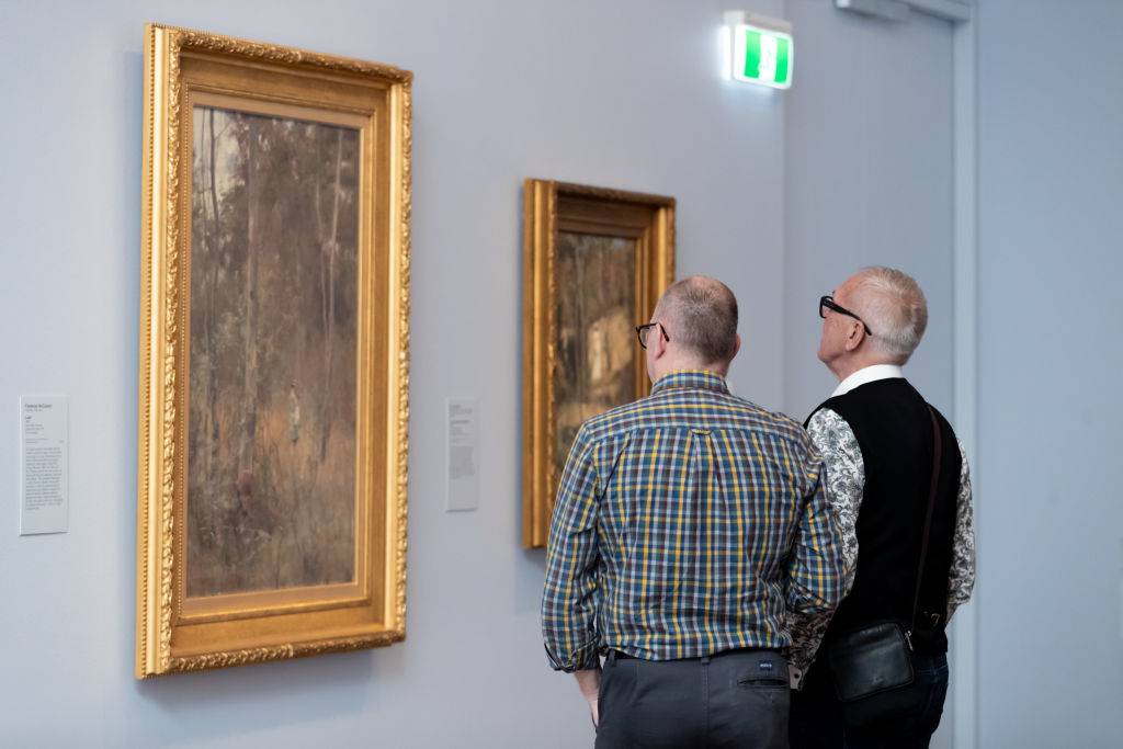 Attendees look at artwork at She-Oak and Sunlight: Australian Impressionism at The Ian Potter Centre: NGV Australia