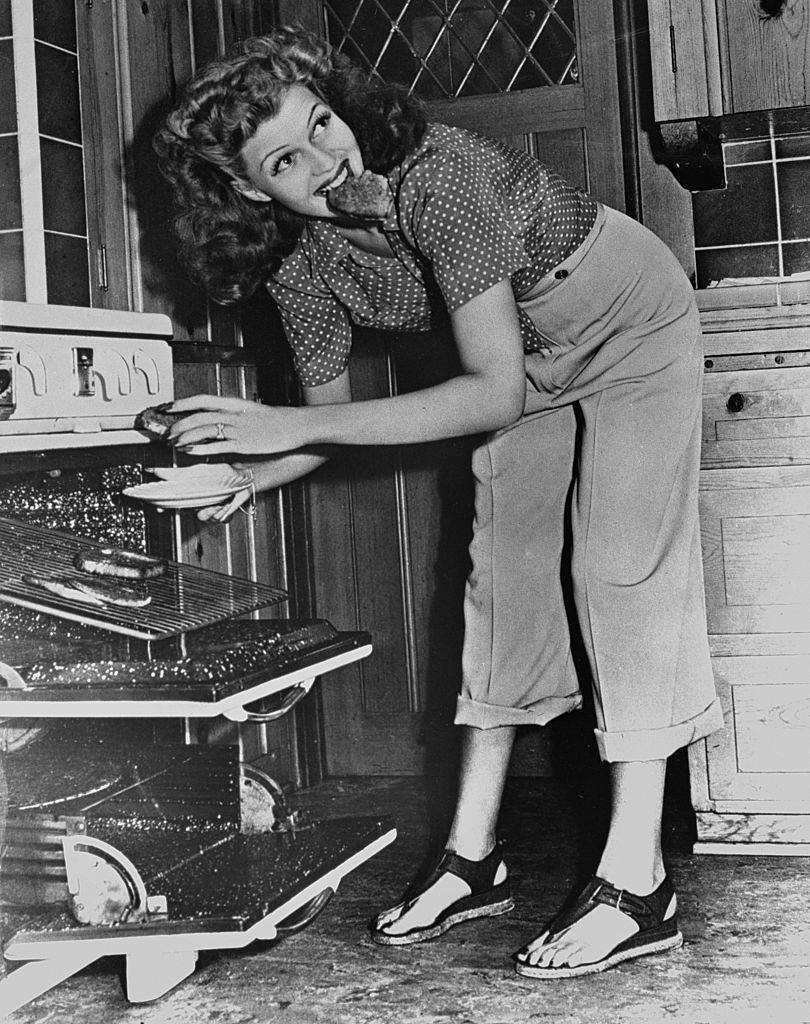 rita hayworth eating food out of the oven