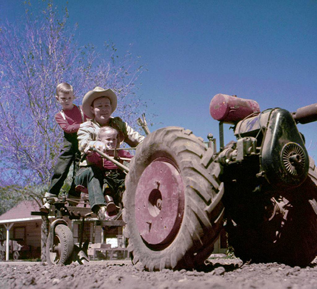 Roy Rogers and sons ride a tractor at home in 1958