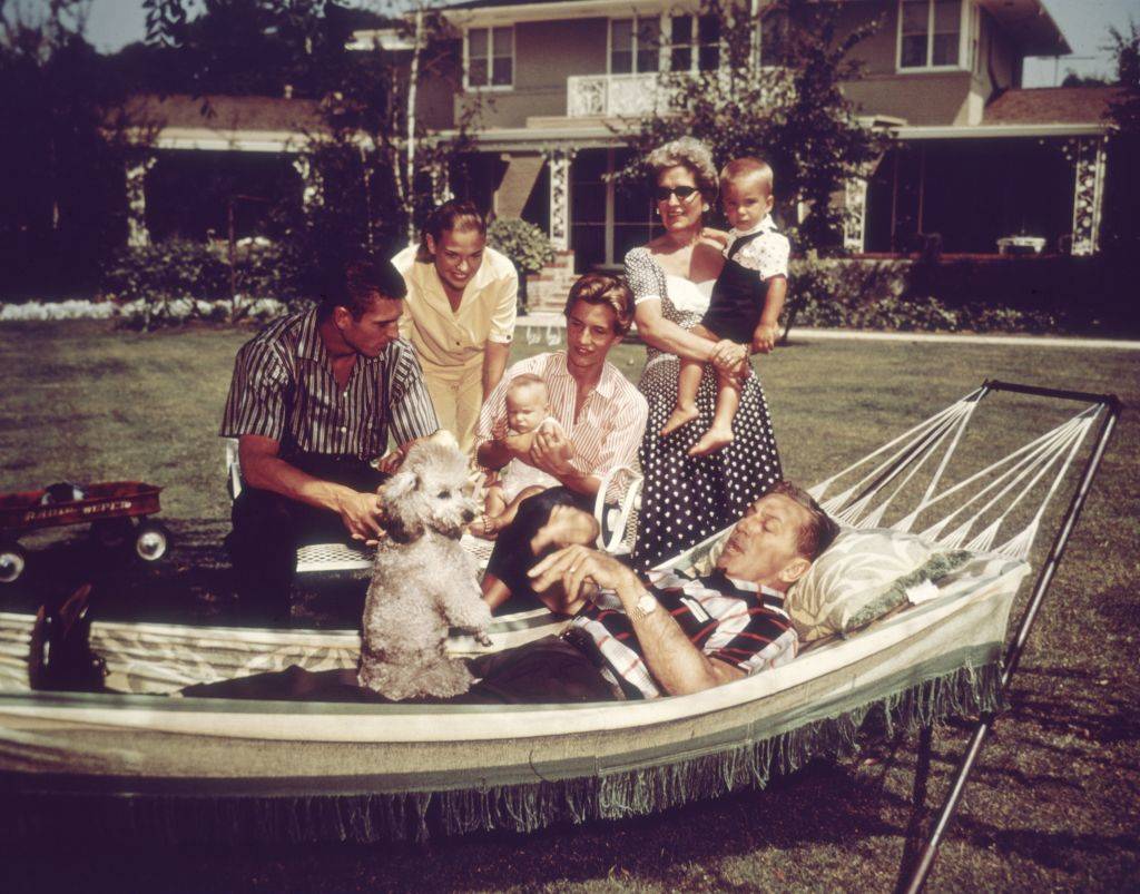 walt disney relaxing on a hammock with his family and their pet dog