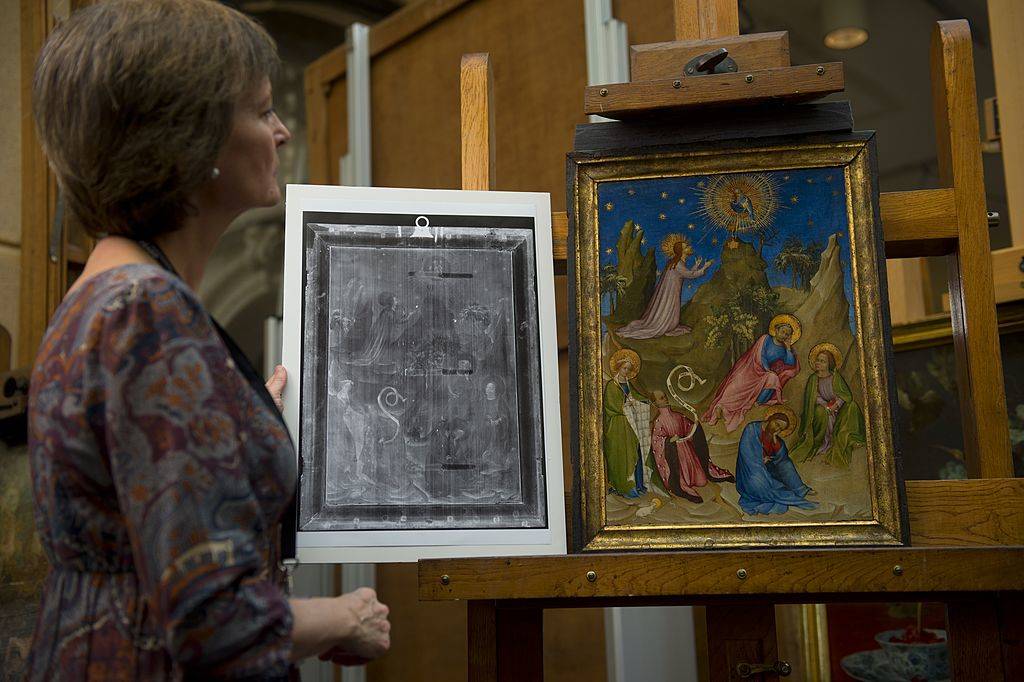 woman looking at x-ray of a painting