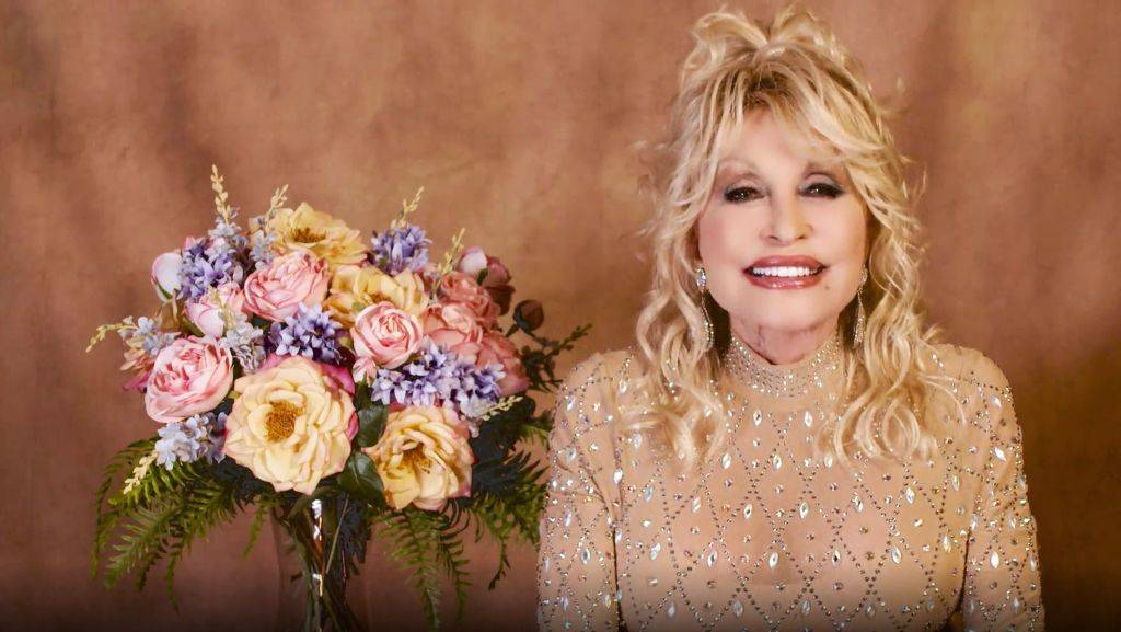 Dolly Parton sitting next to a bouquet of flowers