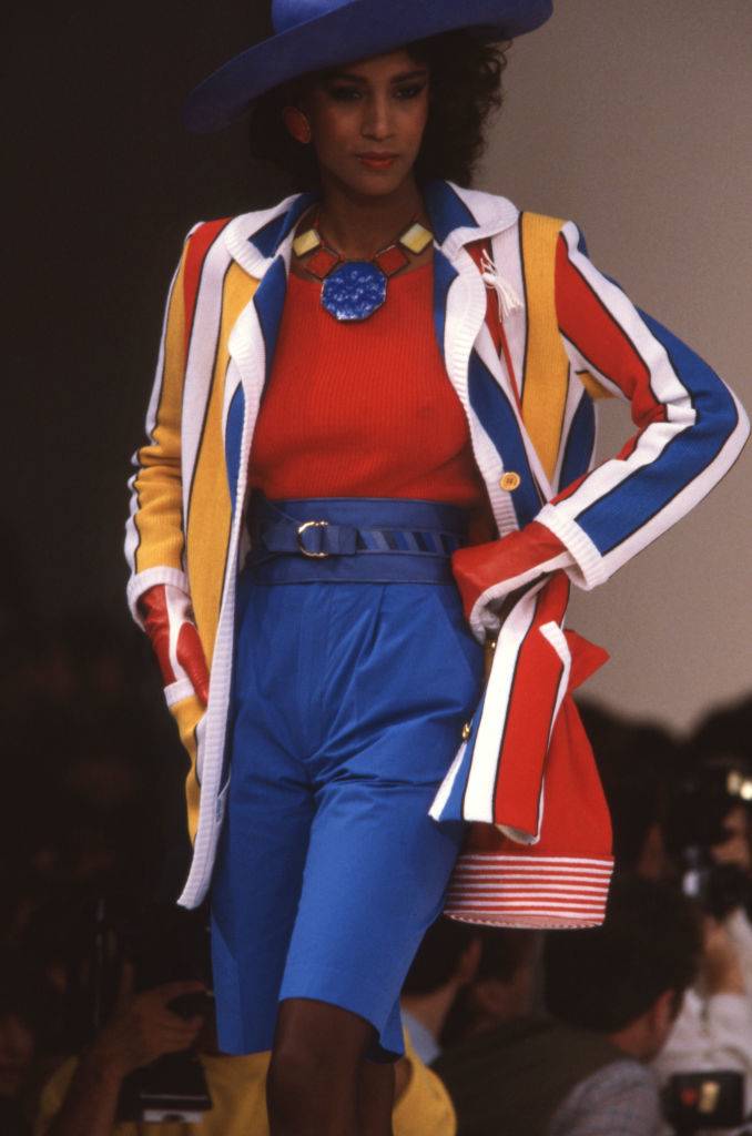 model wearing an outfit with bright colors of yellow, blue, red, and white in the 80s