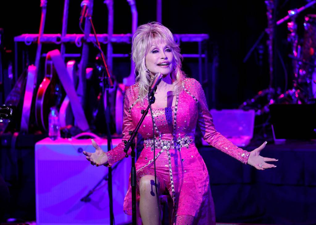 Dolly Parton performing on stage in a pink dress