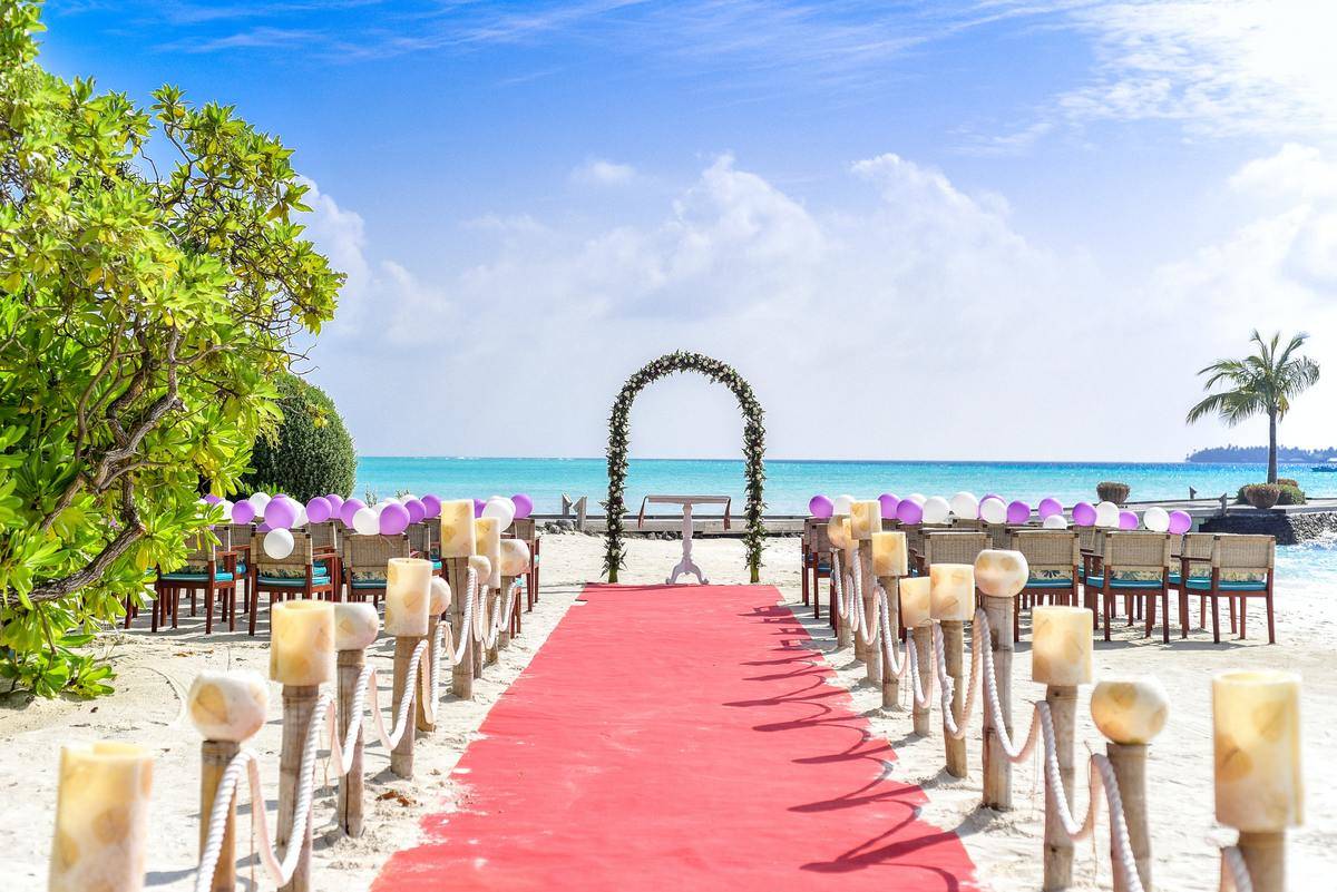 Destination wedding aisle with red carpet and candles