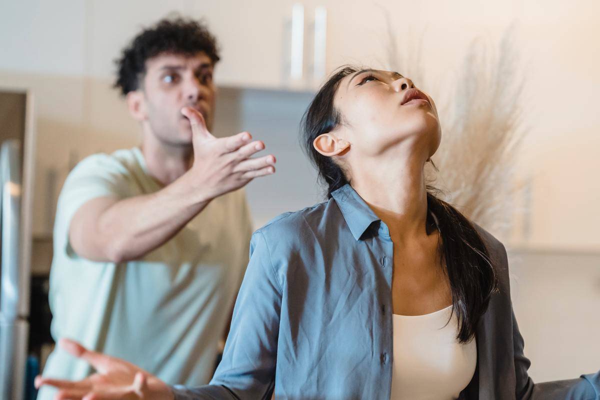 Man yelling at woman with arm outstretched