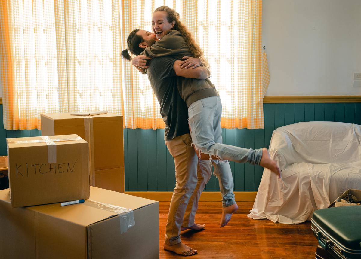 Couple hugging around moving boxes 