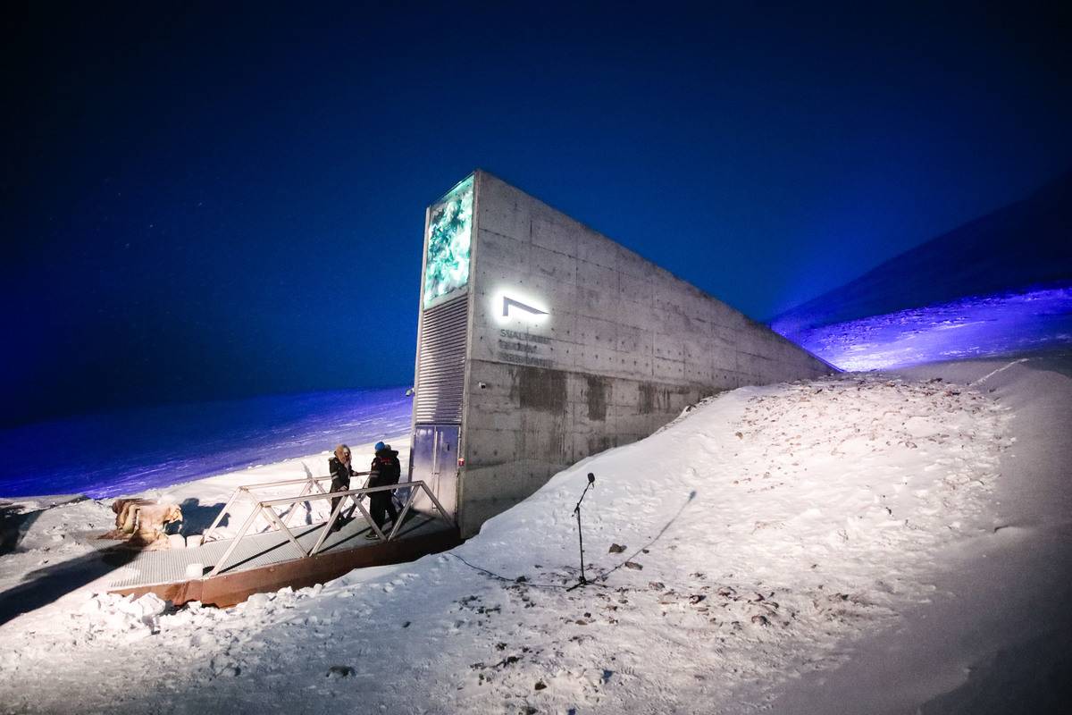 People stand in front of the entrance to the international gene bank Svalbard Global Seed Vault (SGSV), on February 25, 2020 outside Longyearbyen on Spitsbergen, Norway.