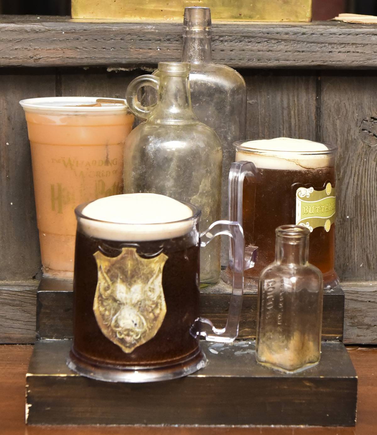 Butterbeer in mason jar mugs on table at Christmas in the Wizarding World of Harry Potter at Universal Studios Hollywood, California