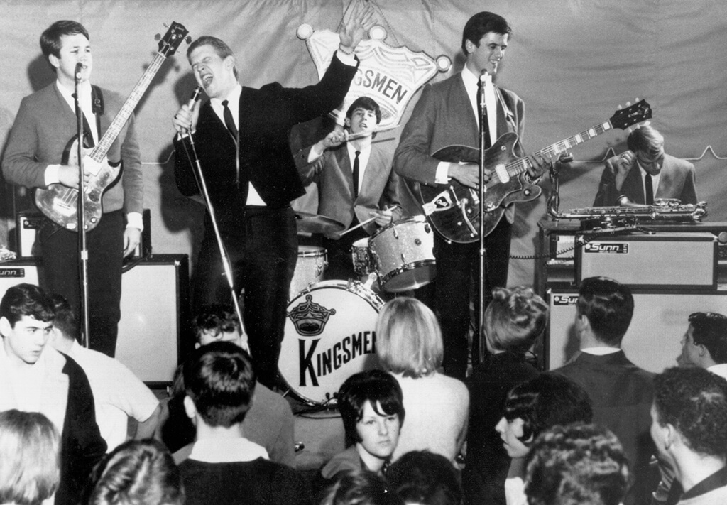 The Kingsmen pictured performing in black and white image