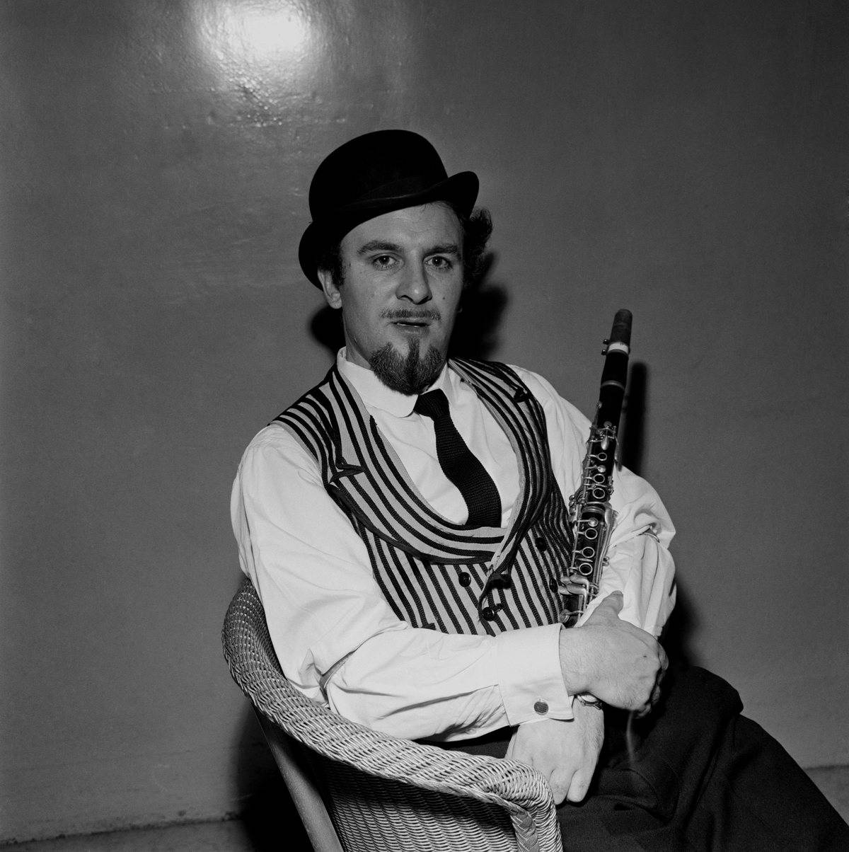 Acker Bilk, posed, with clarinet, wearing waistcoat and bowler hat, 1960.