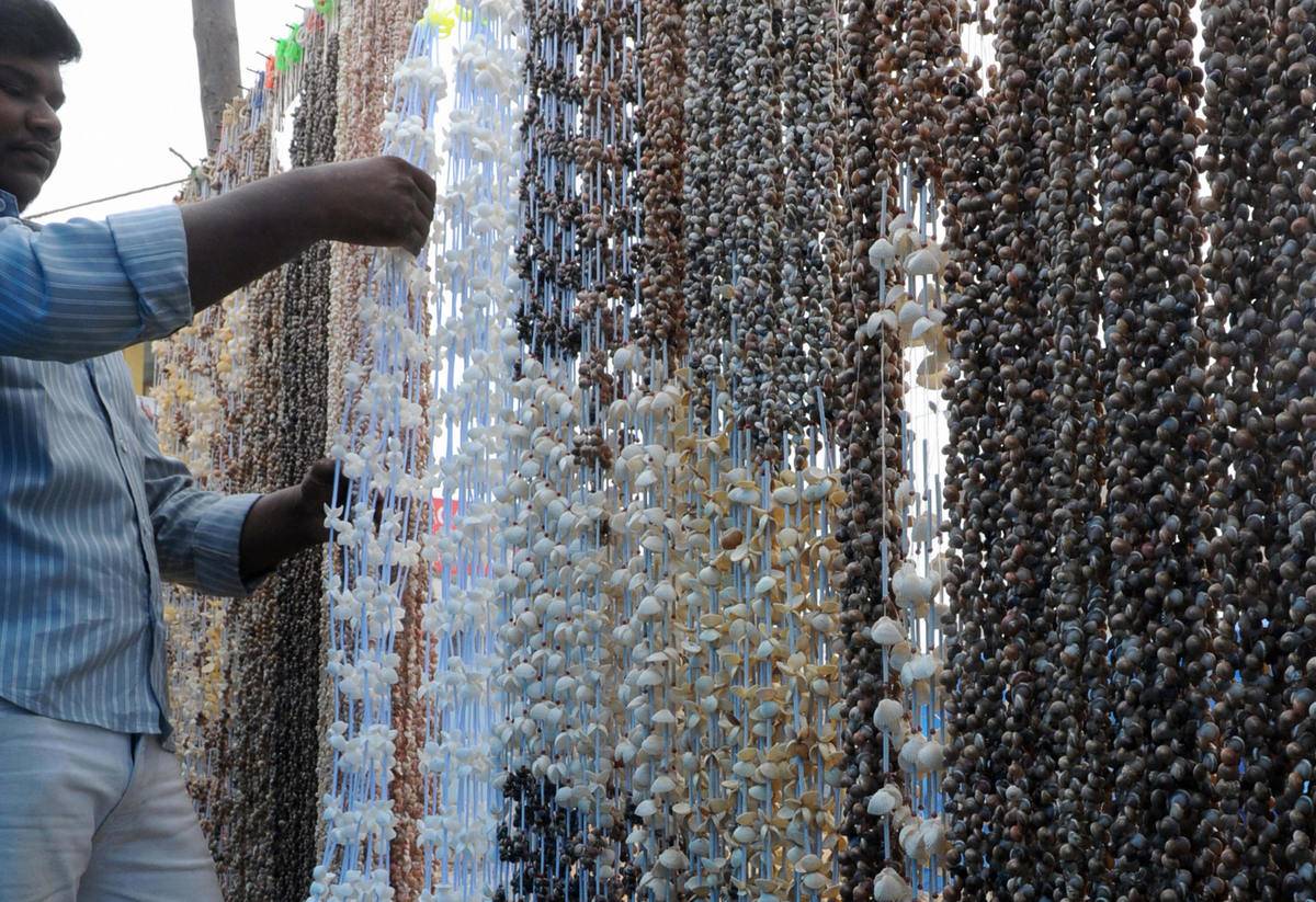 An Indian vendor arranges sea shell garl