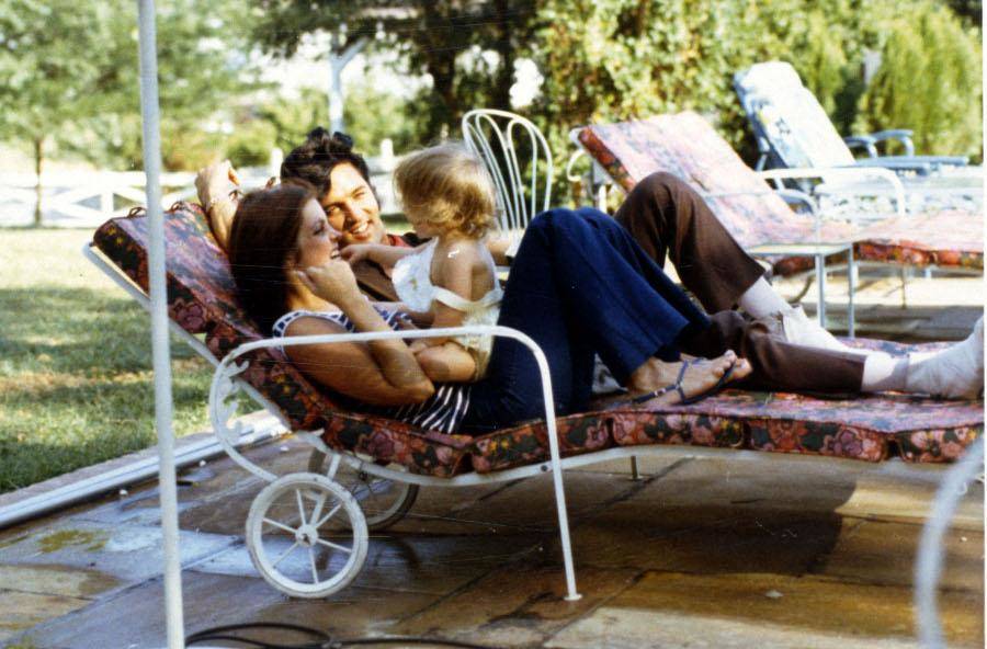 elvis and priscilla and their daughter hanging out on lounge chairs