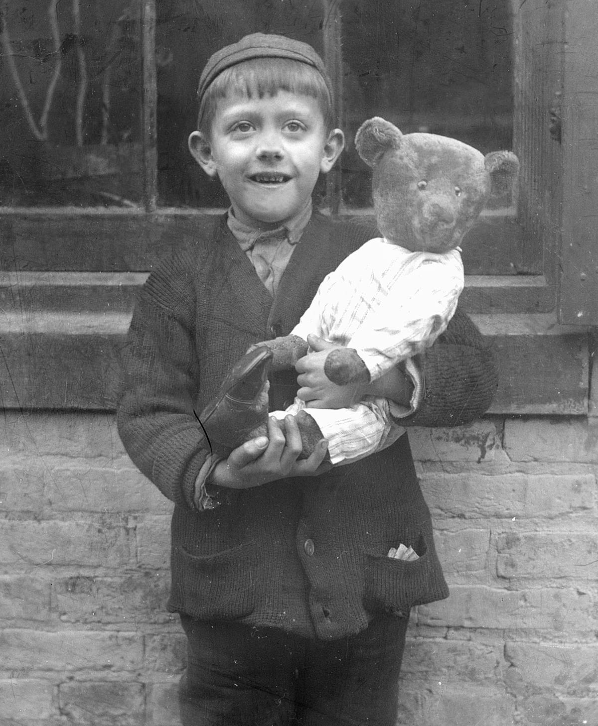 A young boy holds his teddy bear