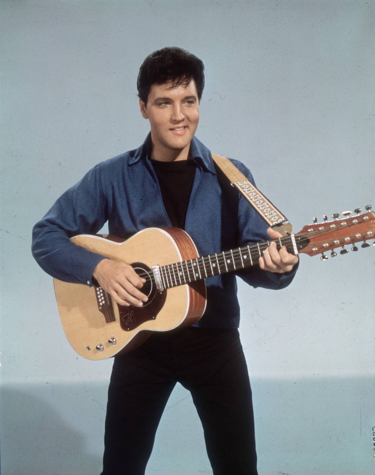 American rock 'n roll singer Elvis Presley (1935 - 1977) with a twelve string guitar circa 1955