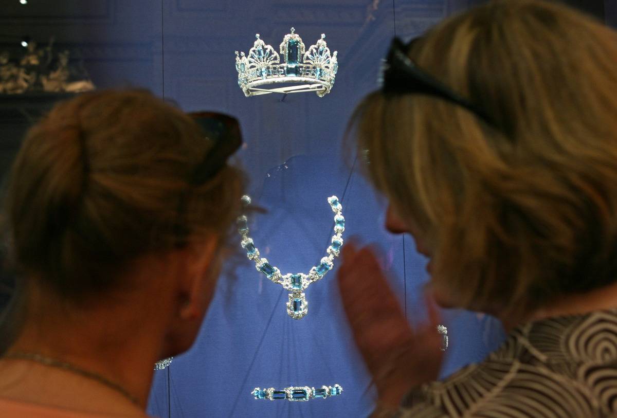 Two visitors look at an aquamarine and diamond tiara from Ga