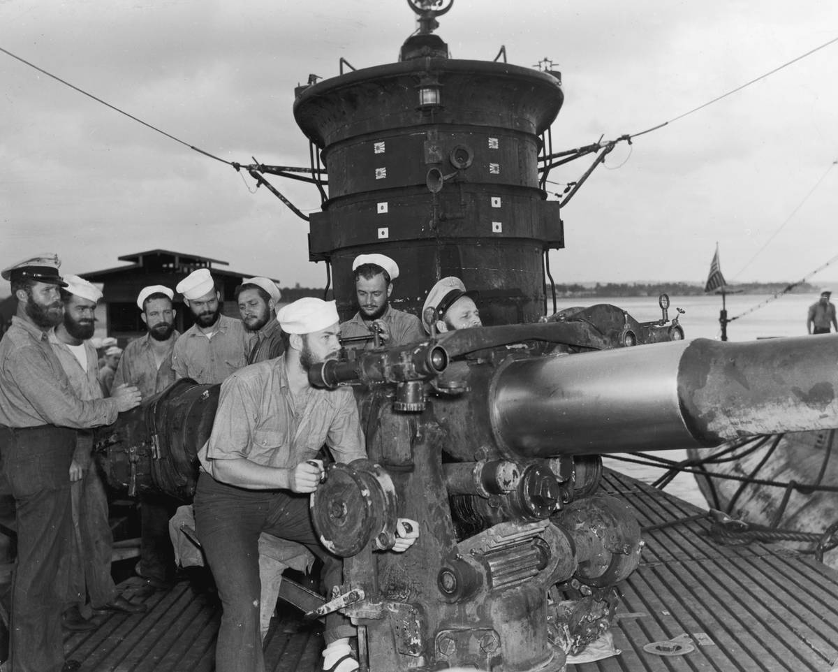 The bearded gun crew of the U.S. submarine, 'Old Betsy,' man a gun above  deck upon returning for an overhaul after a successful South Pacific 
patrol, World War II.