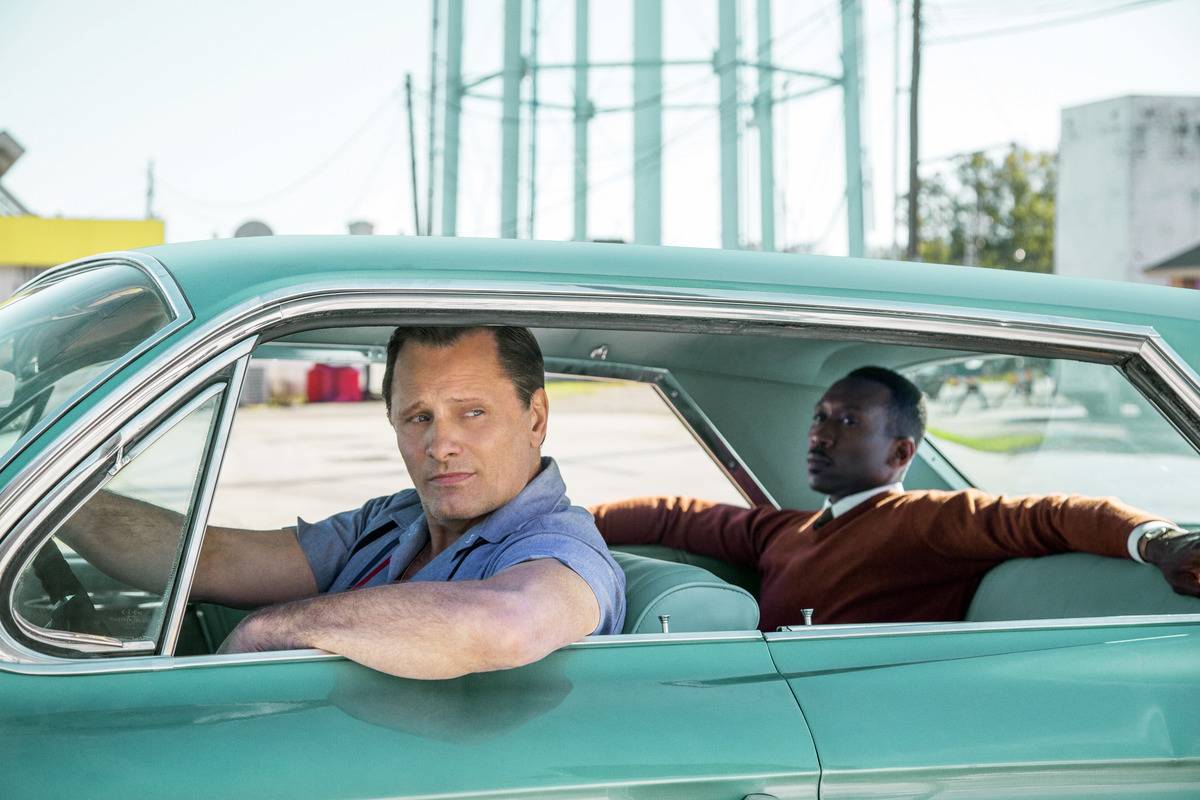 two men in a teal car