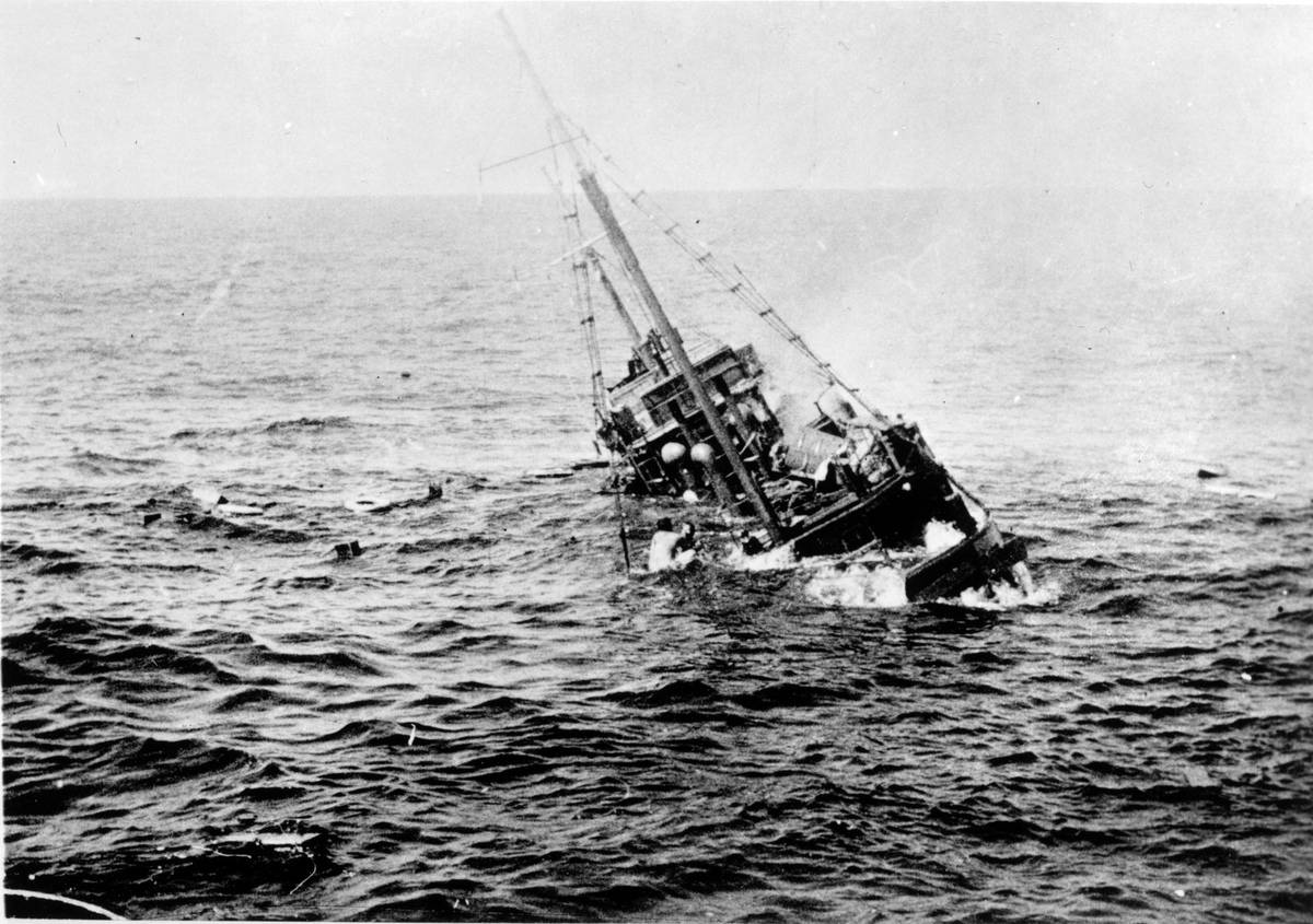 View of the aftermath of the sinking of a Japanese merchant ship by the  US Navy submarine USS Tambor, with survivors visible on the ship's 
rigging, 1944.