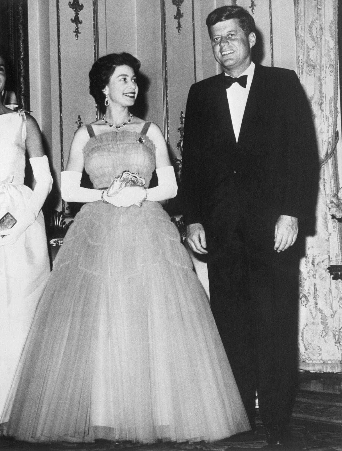 Queen Elizabeth smiles at President John F. Kennedy during a state dinner at Buckingham Palace.