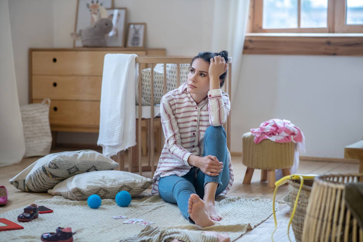 tired-woman-sitting-on-the-floor-in-messy-room-2021-09-04-15-57-02-utc