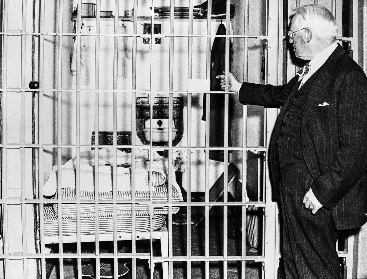 Photo shows the Warden of Alcatraz Federal Penitentiary, James A. Johnston (1874 - 1954), pointing into the cell in which seven prison guards were imprisoned by convicts during an escape attempt which became known as the Battle of Alcatraz.