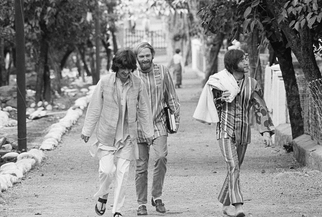 George Harrison, Mike Love, and John Lennon walking in India