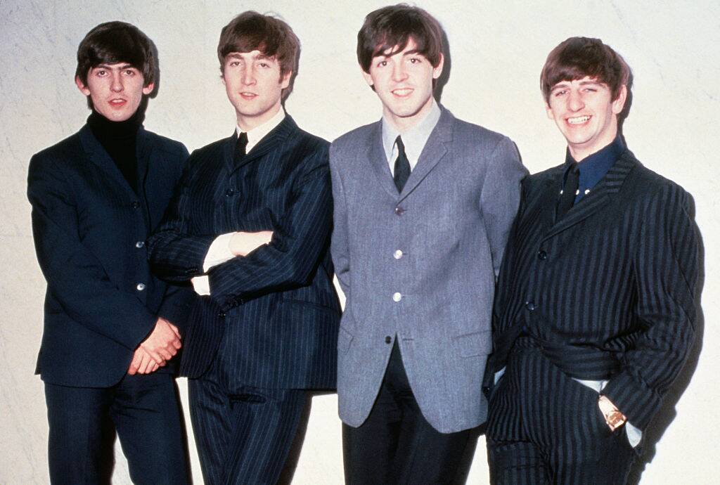 the beatles posing for a photo in 1965