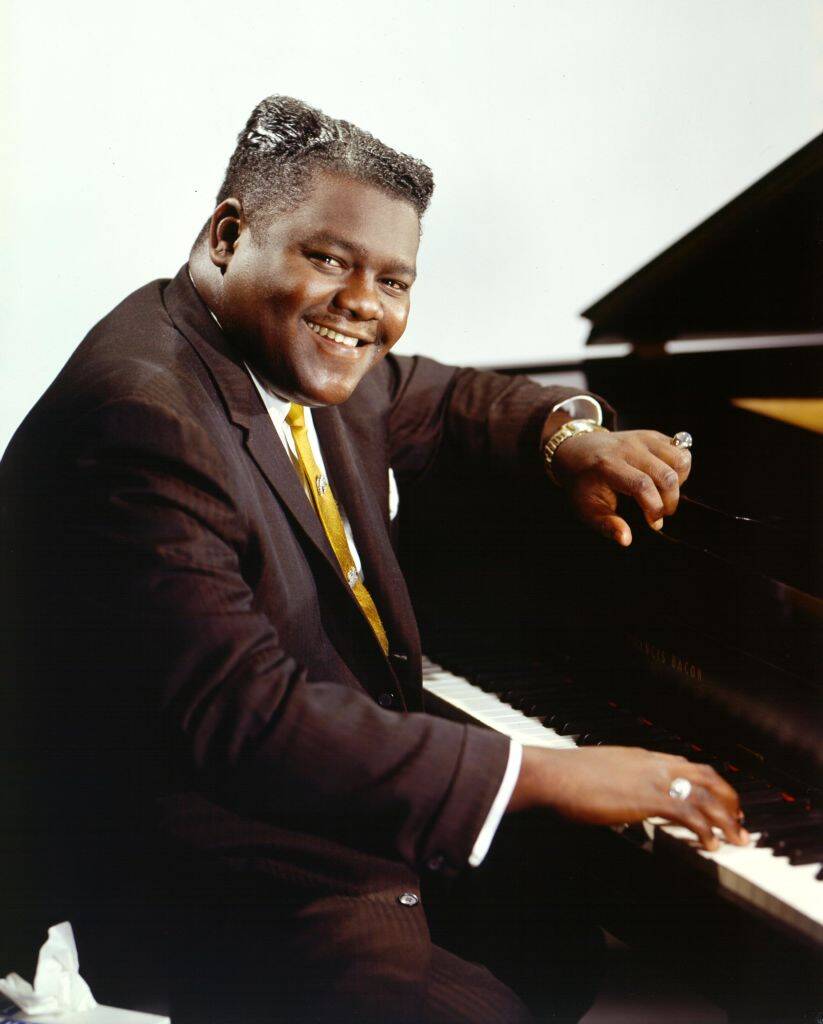 man sitting by the piano
