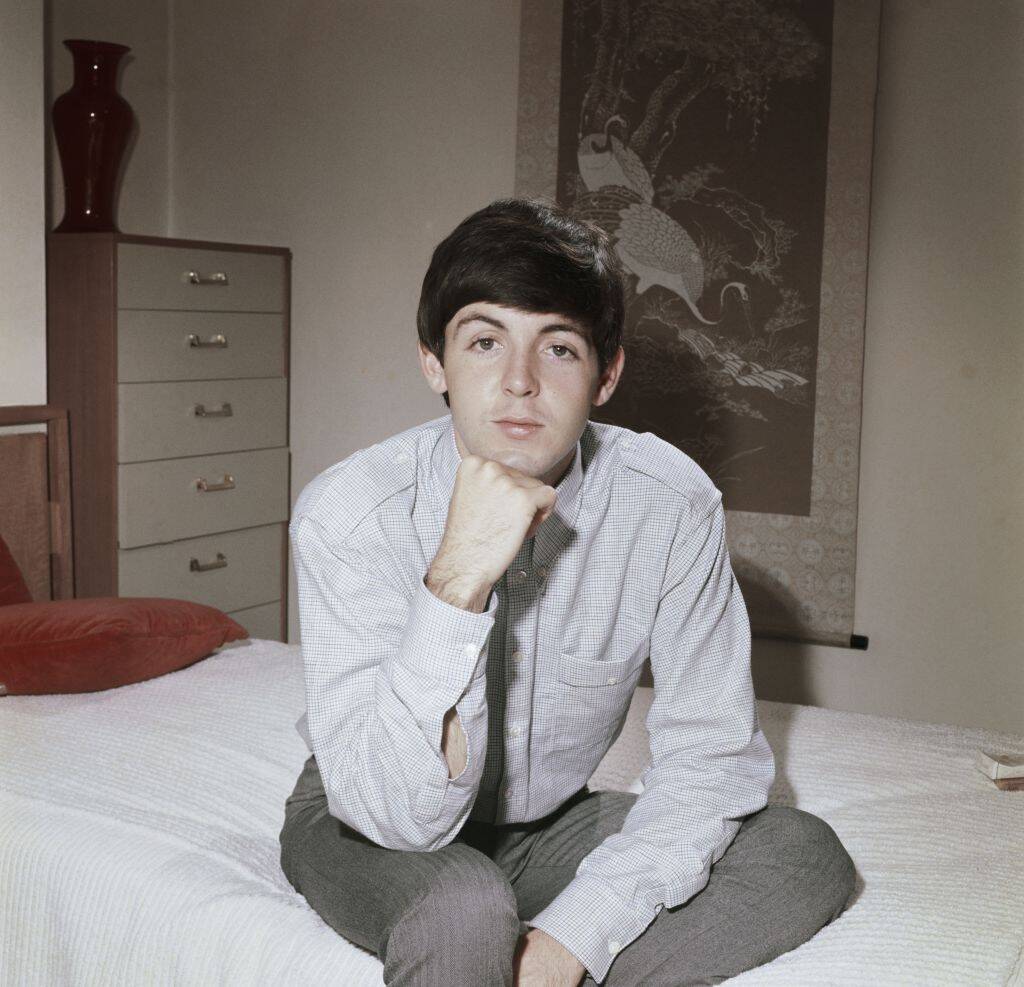 paul mccartney posing on a bed in 1964