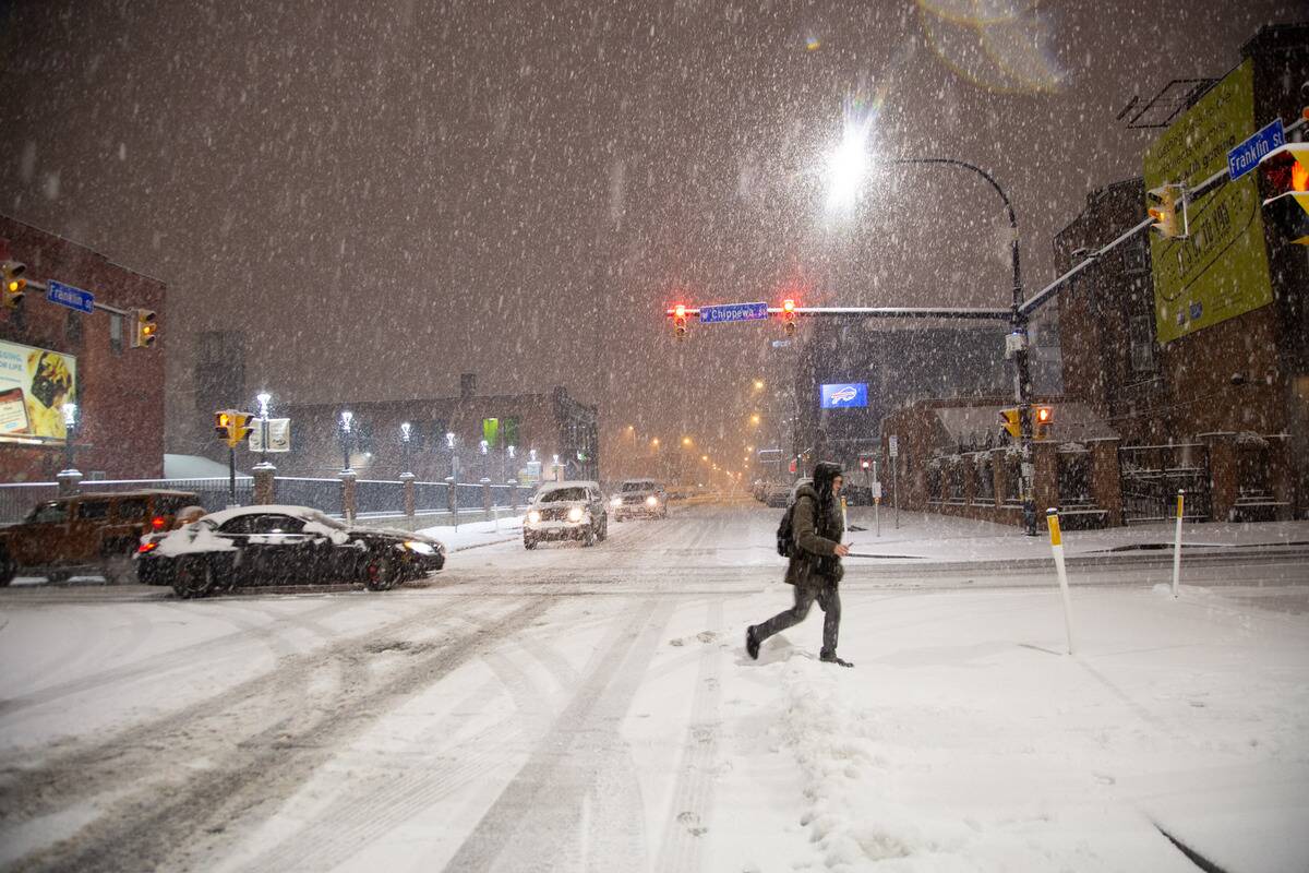 A person crosses Franklin Street during a mid-November storm in Erie County Buffalo, New York 2022.