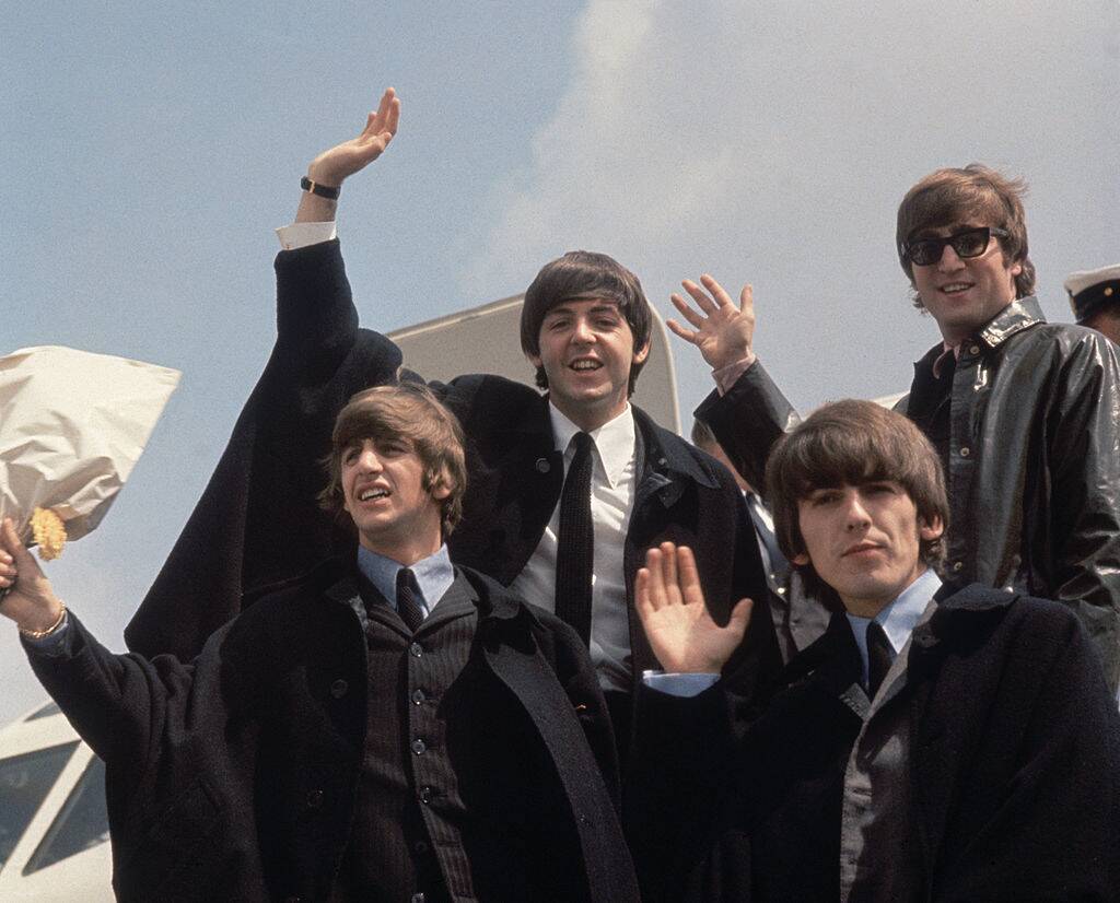 the beatles getting off a plane in 1964