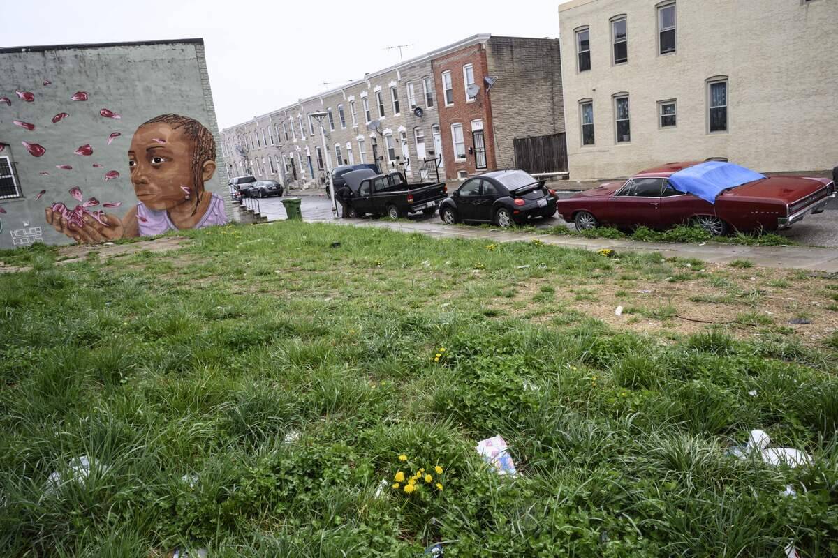 An old Pontiac car is seen beside a mural painting in the McElderry Park area on April 12, 2019 in Baltimore.