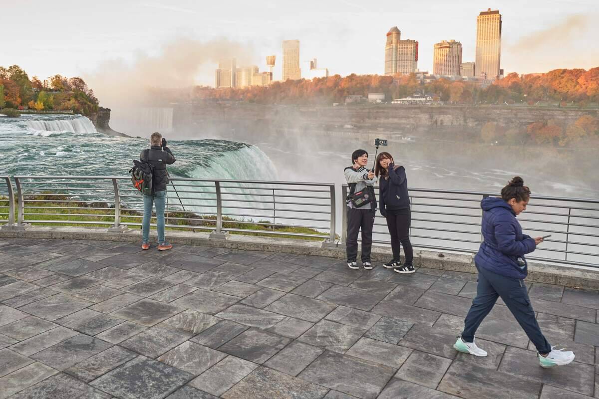 People take a selfie at the American Falls in Niagara Falls, New York on October 25, 2022.