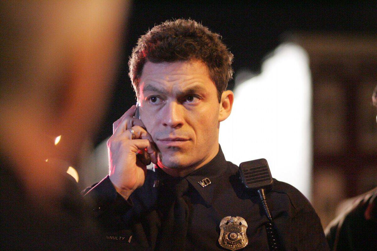 Dominic West holding cell phone up to his face as James McNulty in The Wire