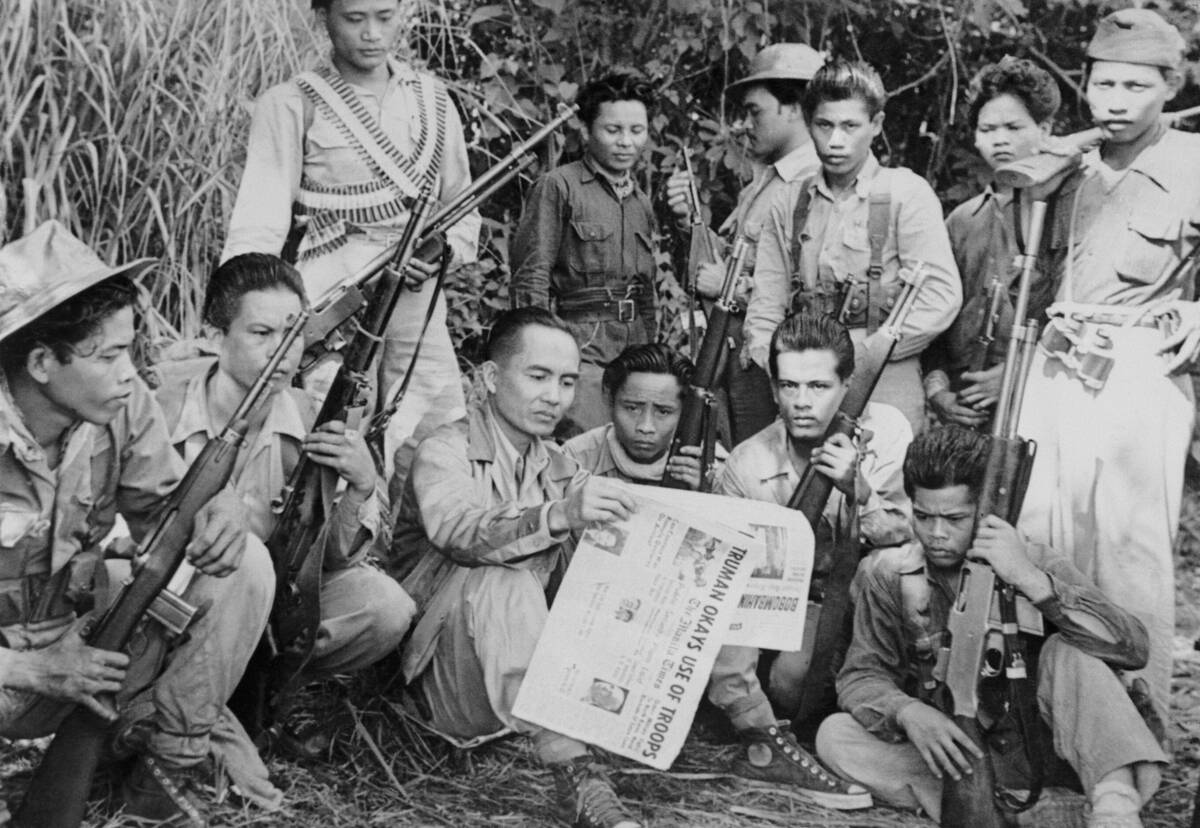 Luis M. Taruc, head man of the Huk Guerrillas in the Philippines, who has often been reported dead by Philippine government intelligence, proves it isn't so by posing for a picture reading a Manila newspaper dated July 1.
