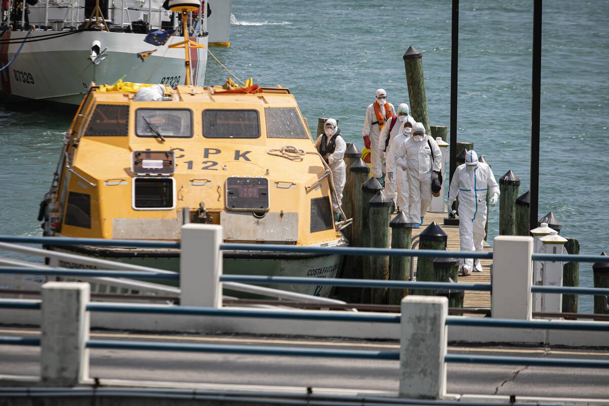 Paramedics dressed in hazmat suits assist the evacuation of cruiseships  crew members with respiratory symptoms associated with coronavirus 
(COVID-19) at the Coast Guardâs Miami Beach station, in Miami, Florida, 
United States on March 26, 2020.