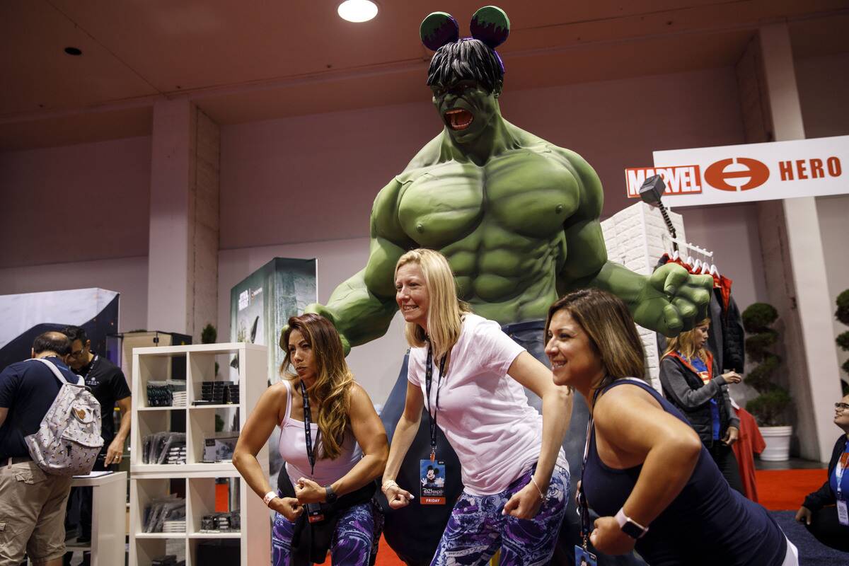 Attendees stand for pictures with Marvel's Hulk wearing Mickey ears  during the D23 Expo 2019 in Anaheim, California, U.S., on Friday, Aug. 
23, 2019.