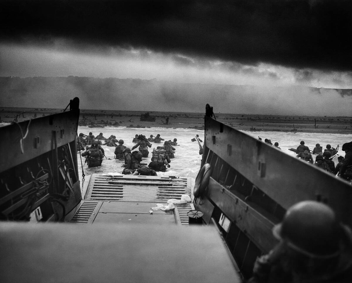 US Troops wading through water after reaching Normandy and landing Omaha beach on D Day, 1944.