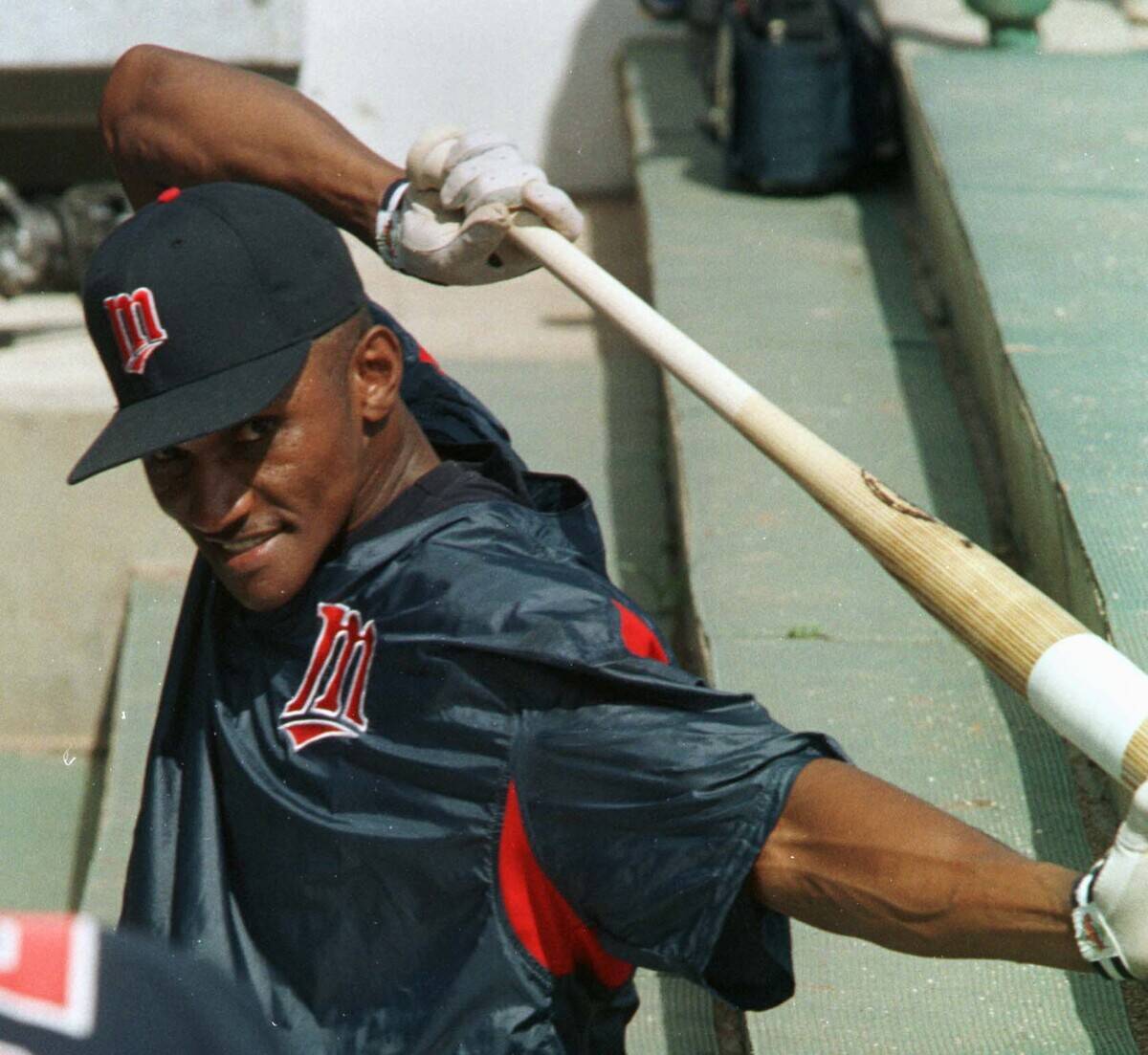 MN TWINS spring Training -- Outfielder Otis Nixon grins at a teammate's joke while taking a break in the dugout during practice Monday.