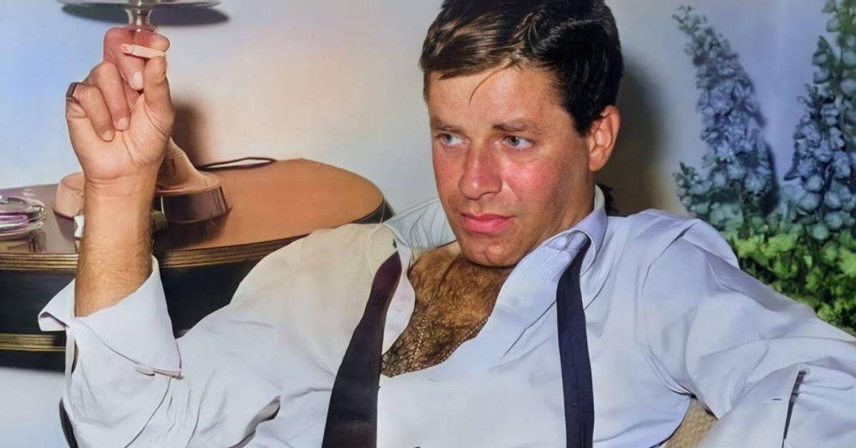 man sitting down with his shirt open