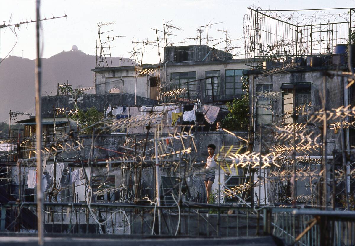 Boy Flies Kite among TV Aerials on Rooftop of Building in Kowloon Walled City, Hong Kong circa 1979