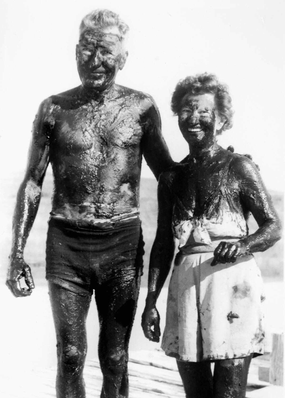 Ma and Pa are coated in mud, ca. 1953