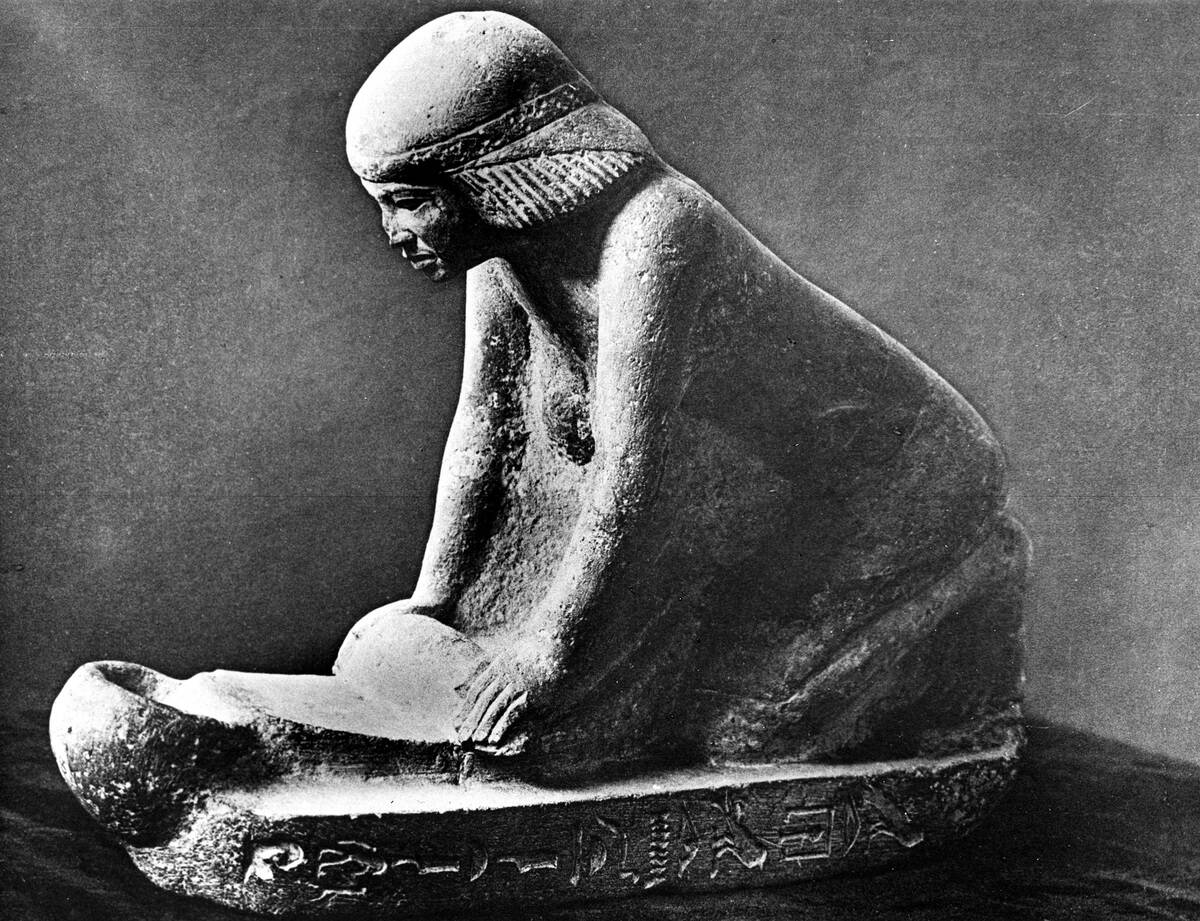 Egyptian tomb figure of a woman grinding corn using a saddle quern, c2500 BC.