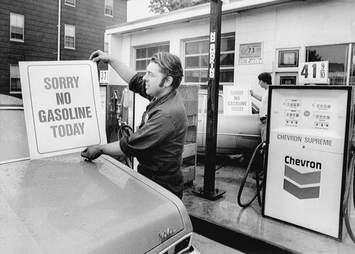 Workers Placing Signs on Gas Pumps