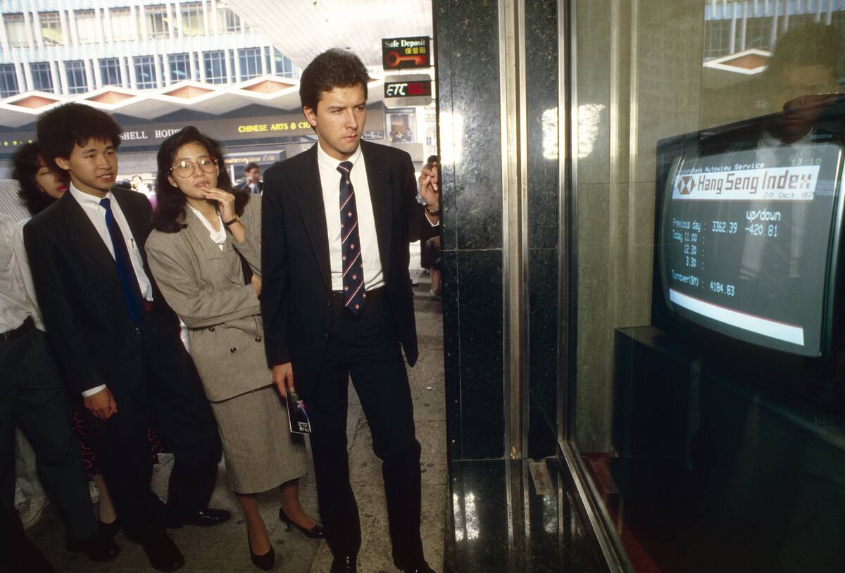 Black Monday. Business people watch a TV monitor in a bank...