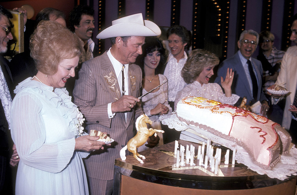 Roy and Dale Cutting Cake shaped like a cowboy boot