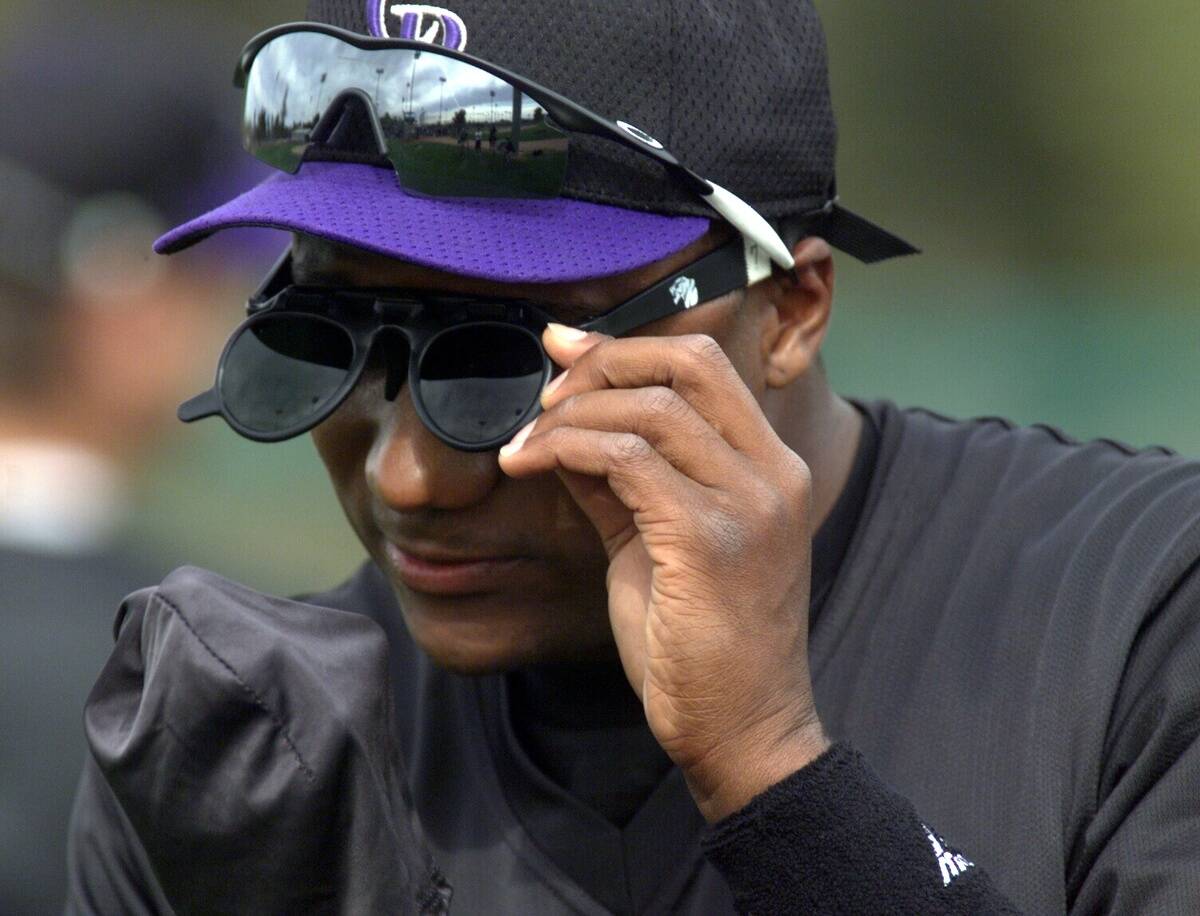 Darryl Hamilton cleans off a pair of flip-up sunglasses for outfield training in Tucson Friday morning.