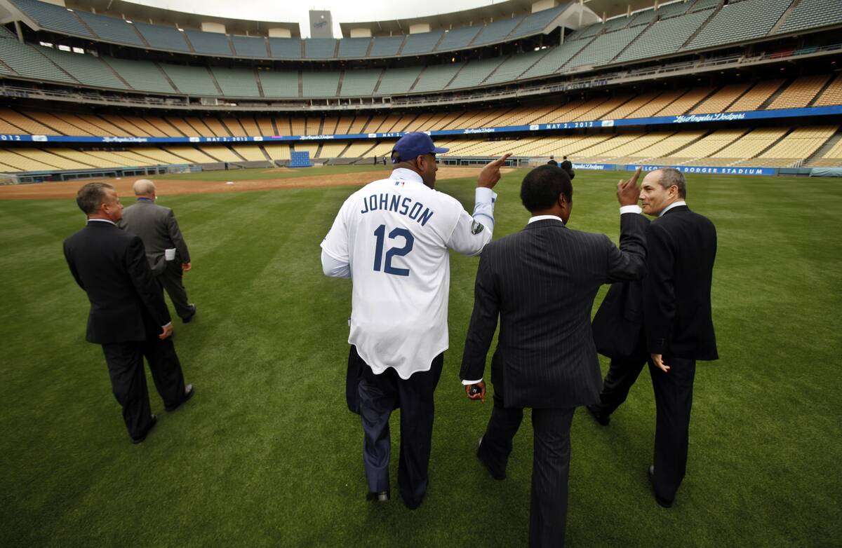 Earvin ``Magic'' Johnson walks through the outfield at Dodgers Stadium talking with reporter Jim Hi