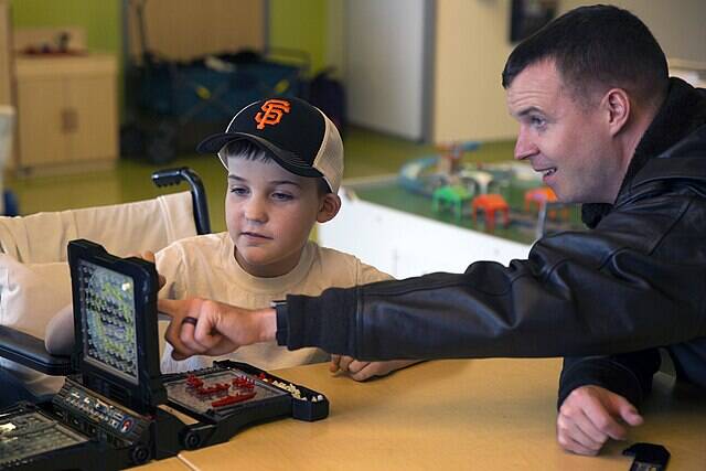 U.S._Navy_Capt._plays_the_board_game_Battleship_with_a_patient_at_Children’s_Hospital._(30116294906)